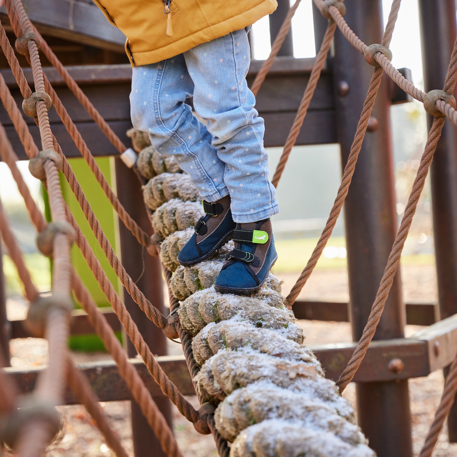 Leguanito Scippo Klett Kinder Barfußschuhe in wasserabweisender Ausführung – Ein Kind spielt fröhlich im Freien, während es die funktionalen und bequemen Barfußschuhe trägt. Die elastische Passform und der Klettverschluss sorgen für einen perfekten Sitz und viel Bewegungsfreiheit. Erhältlich bei barfussweltan.shop.