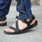 Xero Shoes Z-Trail Kids schwarze Barfuß-Sandalen für Kinder – am Fuß eines Kindes präsentiert, verfügbar im barfussweltan.shop Barfußschuhe Onlineshop